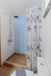a bathroom with a shower curtain with shells on it at Peaceful Stay in Livadia, near Chora and Beach in Vrakhnós +6 photos