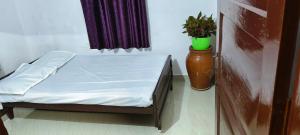 a small bed in a room with a potted plant at White Sands Cottage in Alleppey +8 photos