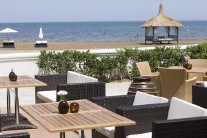 a patio with tables and chairs and the beach at Villa Fratello in Baku