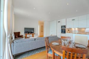 a living room with a couch and a table with chairs at Les Terrasses de Lavaux-3 Appartement luxueux avec vue sur lac et piscine in Puidoux