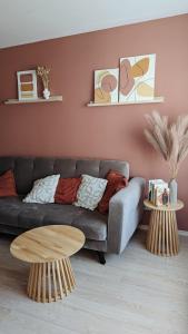 a living room with a couch and two tables at Ezerkrasta apartamenti in Liepāja