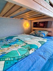 a bed with a blue comforter in a bedroom at Charming Family Villa in Ulricehamn