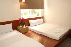 deux lits jumeaux dans une chambre avec fenêtre dans l'établissement Khách sạn Hoàng Bách, à Vung Tau