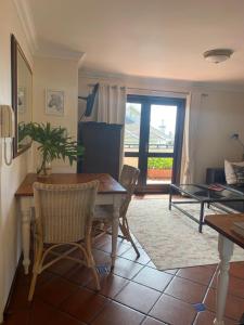 a living room with a table and chairs and a window at Bakoven Cottage in Cape Town