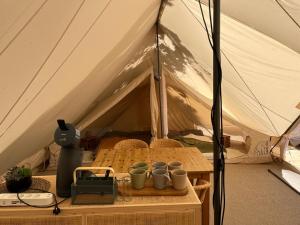 a tent with a table with mugs on it at Kleine Freiheit 6- Waldlichtung in Reichendorf