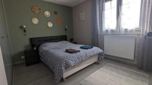 een slaapkamer met een bed en een raam bij Chez Romain, appartement proche commerces et centre ville in Verdun-sur-Meuse