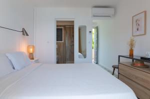a white bedroom with a large white bed at HOTEL CAMPOMORO in Belvédère-Campomoro