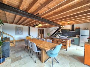 eine Küche und ein Esszimmer mit einem Holztisch und Stühlen in der Unterkunft Chez Bob - Grange de Charme in Olloix