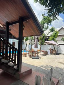 a patio with tables and umbrellas and a pool at Luangprabang Residence Boutique Hotel in Luang Prabang