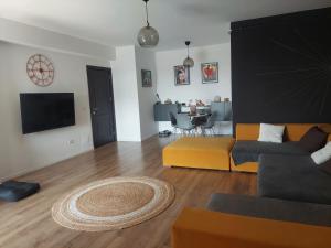 a living room with a yellow couch and a table at Best City View in Craiova