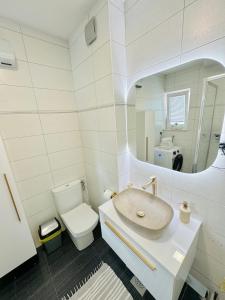 a bathroom with a sink and a toilet and a mirror at Apartments LUPE in Split +13 photos