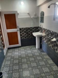 a bathroom with a sink and a door in it at MNT Homestay Chitkul By Soma Stays in Chitkul
