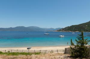 a view of a beach with boats in the water at HOTEL CAMPOMORO in Belvédère-Campomoro