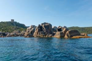 a group of rocks in the water near the ocean at HOTEL CAMPOMORO in Belvédère-Campomoro