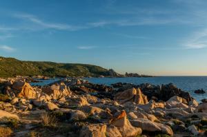 a group of rocks on the shore of the ocean at HOTEL CAMPOMORO in Belvédère-Campomoro
