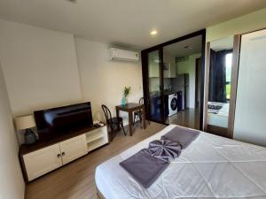 a bedroom with a bed and a flat screen tv at The Base Central Phuket-B32YJ in Ban Rangeng