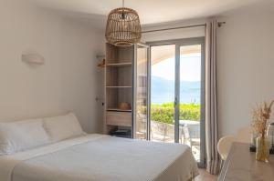 a bedroom with a bed and a view of the ocean at HOTEL CAMPOMORO in Belvédère-Campomoro