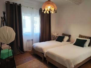 プラン・ド・ラ・トゥールにあるBel Appartement plein centre avec Balcon, climのベッド2台とシャンデリアのある寝室