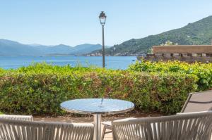 a table and two chairs and a table with a view of the water at HOTEL CAMPOMORO in Belvédère-Campomoro