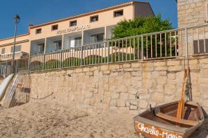 a stone wall in front of a building at HOTEL CAMPOMORO in Belvédère-Campomoro