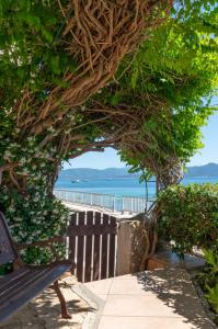 a bench sitting on a sidewalk near the beach at HOTEL CAMPOMORO in Belvédère-Campomoro