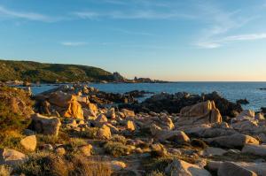 a group of rocks on the shore of the ocean at HOTEL CAMPOMORO in Belvédère-Campomoro