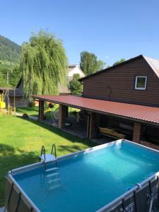 a swimming pool in front of a house at Будинок з лазнею in Mizhhirya