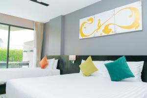 a hotel room with two beds and a window at Beachfront and Deluxe Pool Access Patong Phuket in Patong Beach