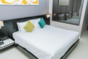 a bedroom with a white bed with a black headboard at Beachfront and Deluxe Pool Access Patong Phuket in Patong Beach