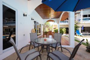 a patio with a table and chairs and an umbrella at V201 1BR Pool Access Walk to Yanui Beach in Nai Harn Beach