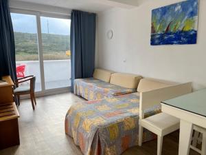 a hotel room with two beds and a desk at Sintra Sol - Apartamentos Turisticos in Sintra
