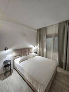 sypialnia z dużym białym łóżkiem i oknem w obiekcie Apartments Cocaletto5 w Rovinj