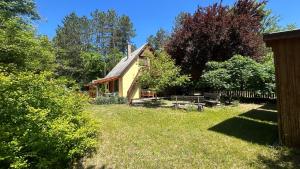 a small house in the middle of a yard at Forest-side home by recreational lake in Kunfehértó