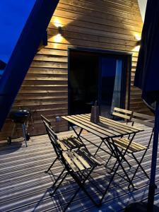 una mesa de madera y 2 sillas en una terraza en Lodge Lady Tipi 2, 