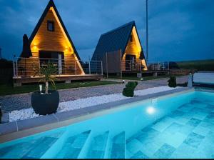 a house with a swimming pool in front of it at Lodge Lady Tipi 2 avec jacuzzi et piscine in Saint-Utin