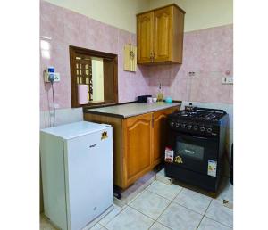 a kitchen with a white refrigerator and a stove at A private bedroom in a shared home in Arusha in Arusha