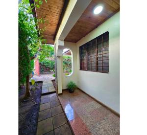 a porch of a house with a window and a tree at A private bedroom in a shared home in Arusha in Arusha +5 photos