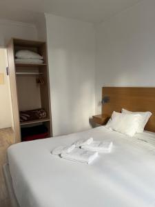 a bedroom with a white bed and a closet at Sintra Sol - Apartamentos Turisticos in Sintra