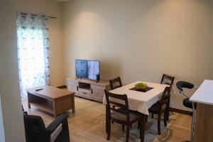 a dining room with a table and a tv at Sren Self catering Apartment in Anse Royale