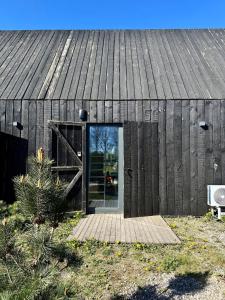 a wooden building with a door in the middle at Svencele mini cottage apartment in Svencelė