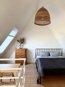 a bedroom with a bed and a table and a window at Svencele mini cottage apartment in Svencelė