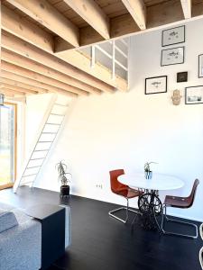 a room with a table and chairs and a staircase at Svencele mini cottage apartment in Svenele