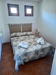 a bedroom with a bed with towels on it at Casa Alma in Olbia