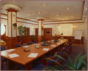 una sala de conferencias con una larga mesa de madera y sillas en Zum Alten Brauhaus, en Hofgeismar