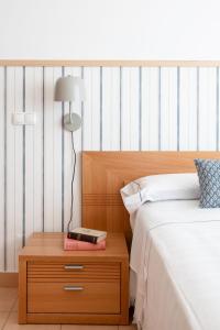 a bedroom with a bed and a nightstand with a lamp at La Francesa Algarve in Monte Gordo