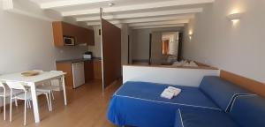 a small room with a blue bed and a table at Sintra Sol - Apartamentos Turisticos in Sintra