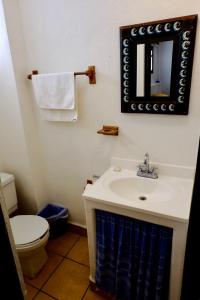 a bathroom with a sink and a toilet and a mirror at Villa Sophie 3BR3BA Beachfront Terrace Heated Pool New Listing in Sayulita