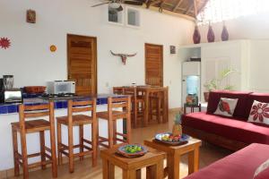 a living room with a red couch and a kitchen at Villa Sophie 3BR3BA Beachfront Terrace Heated Pool New Listing in Sayulita