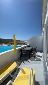 a balcony with a table and chairs and a pool at Sintra Sol - Apartamentos Turisticos in Sintra
