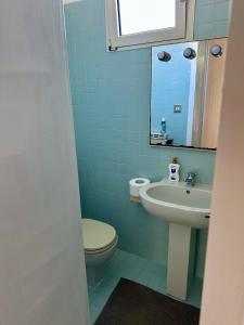 a blue bathroom with a toilet and a sink at Dori Affittacamere in San Lorenzo +20 photos